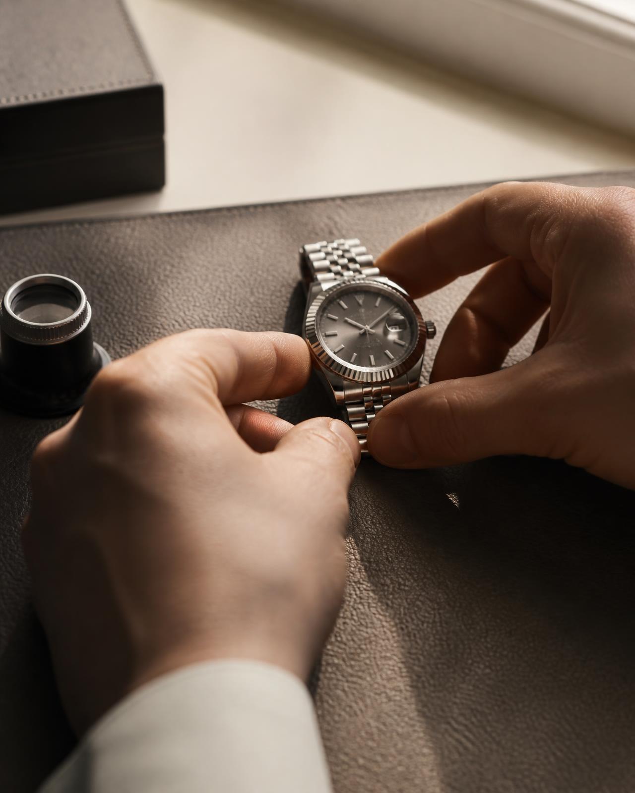 Hands examining a luxury watch during a private valuation